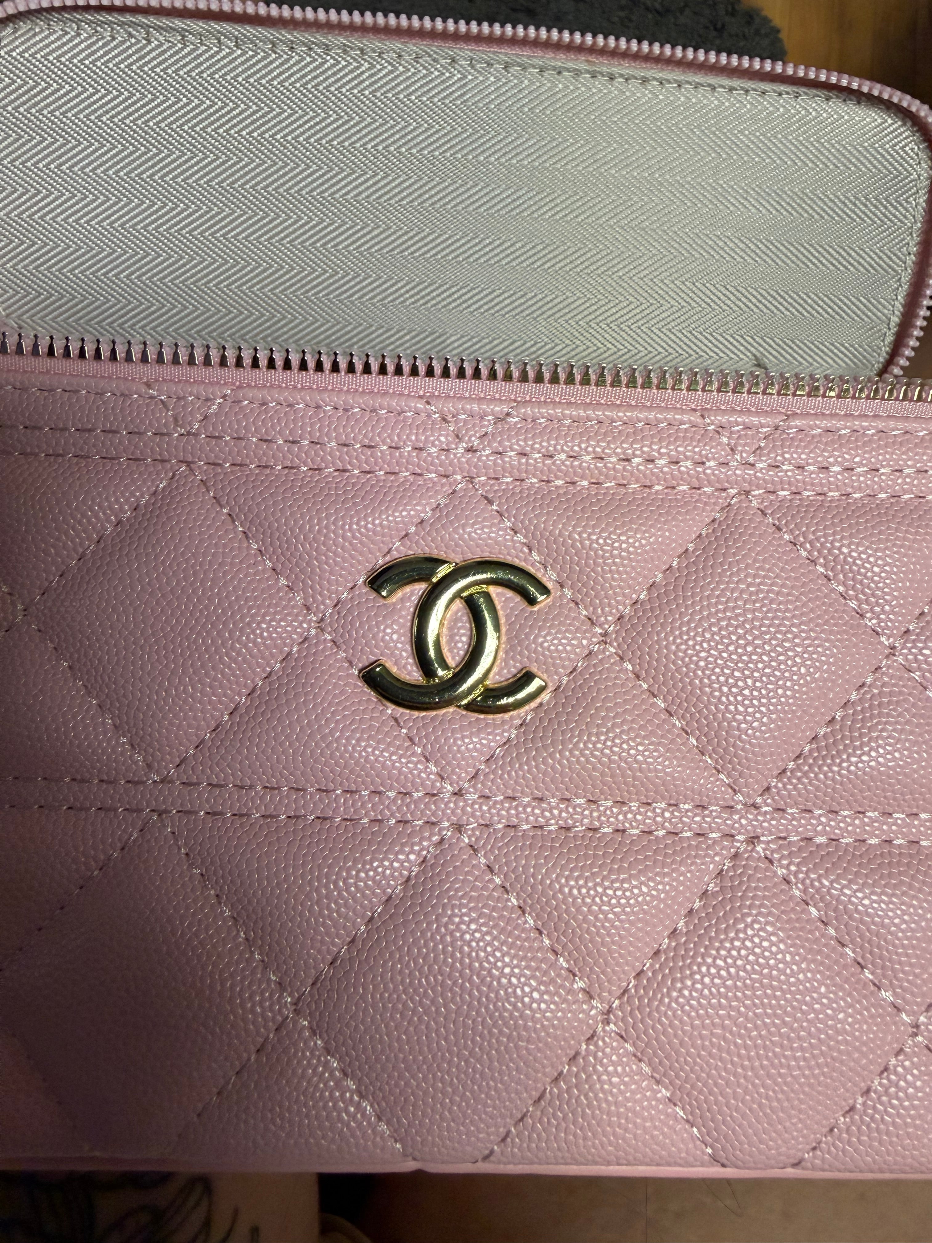 Ce sac vanity case Chanel rose est confectionné en cuir matelassé et agrémenté d'une chaîne dorée.